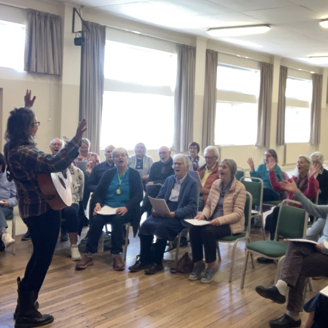 group of people singing with facilitator